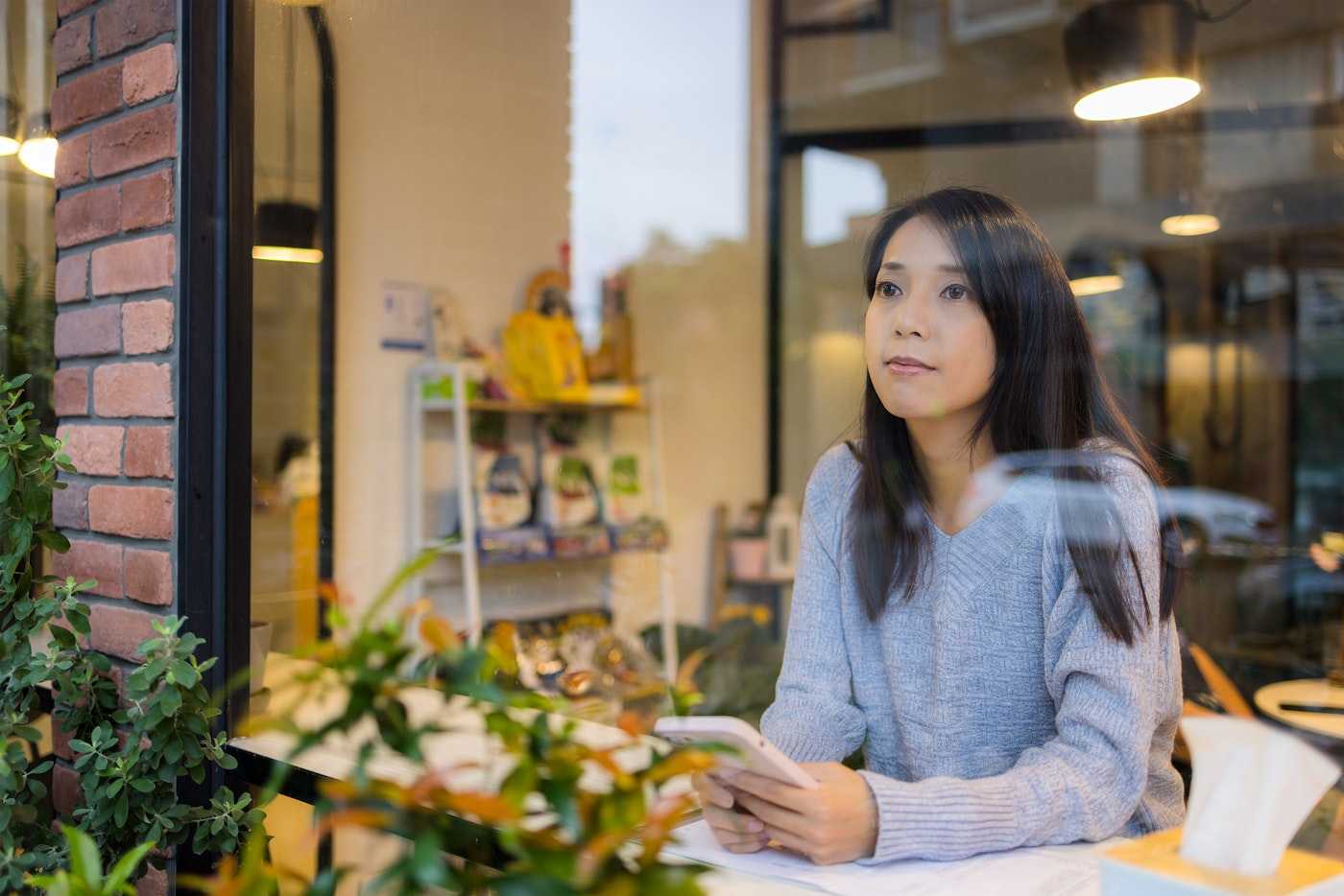 Woman staring into space from cafe