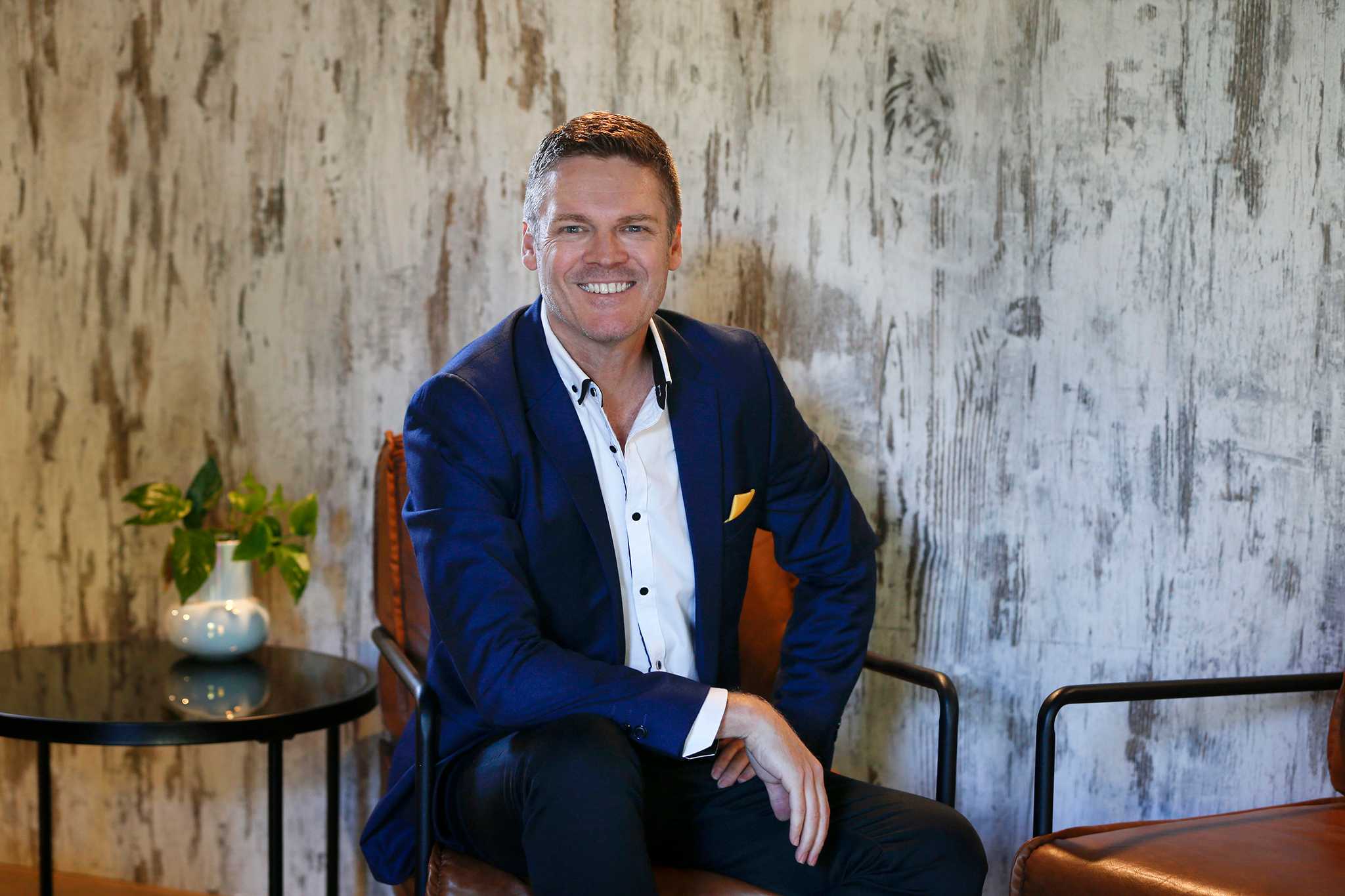 Photo of Simon - Director of Belong Creative seated and wearing a blue suit