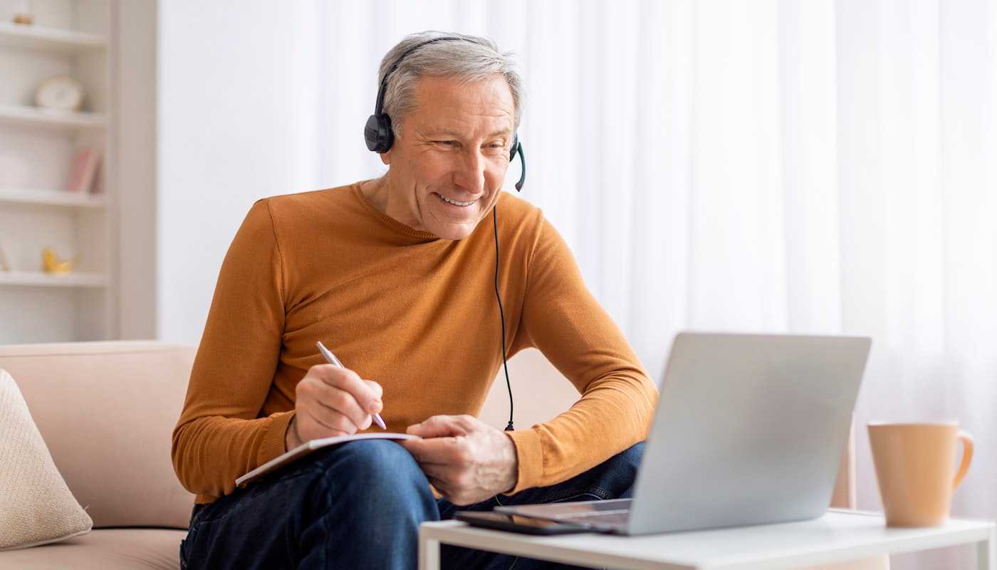 elderly man learning on laptop