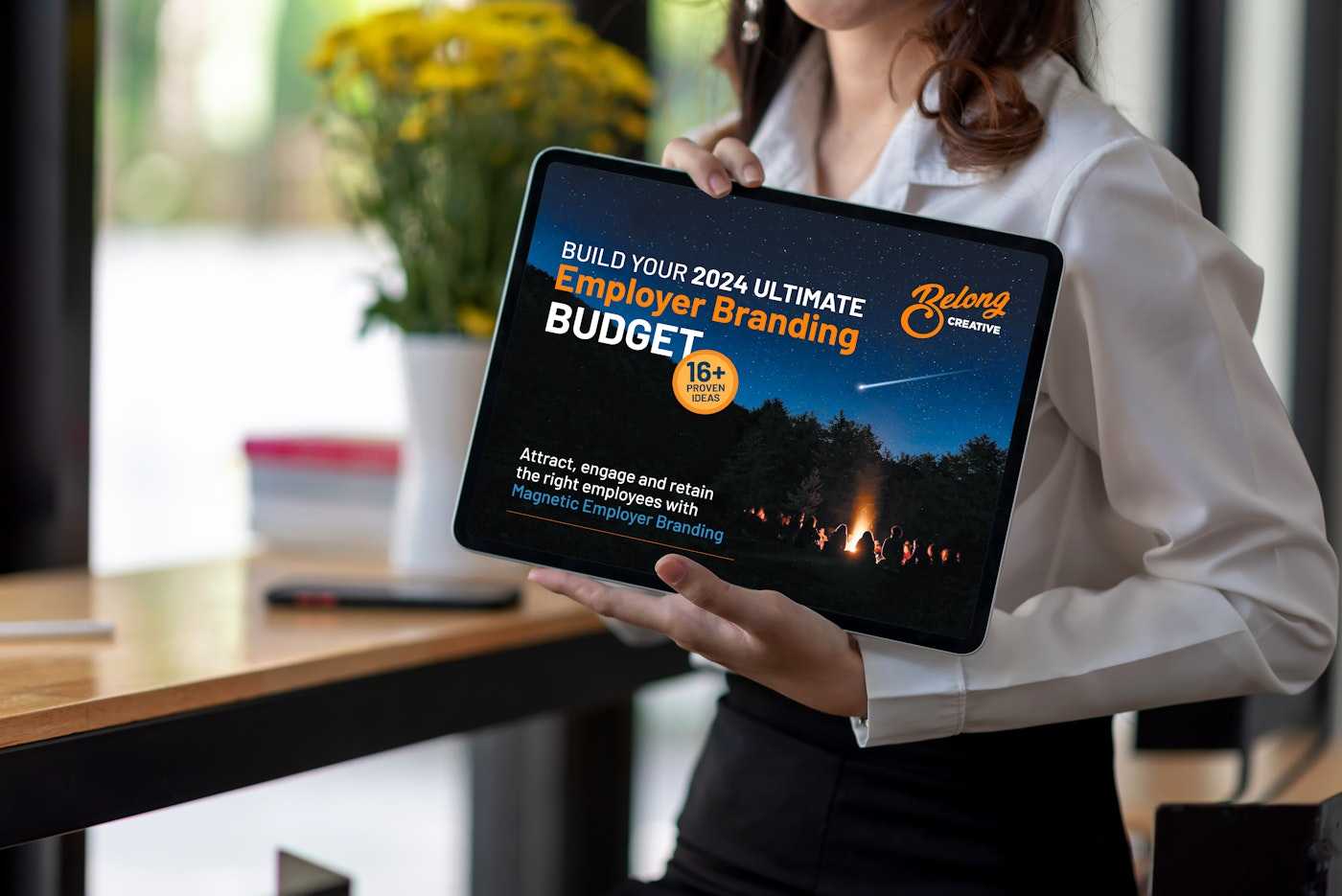 Woman holding ipad with Employer Brand ultimate budget ebook