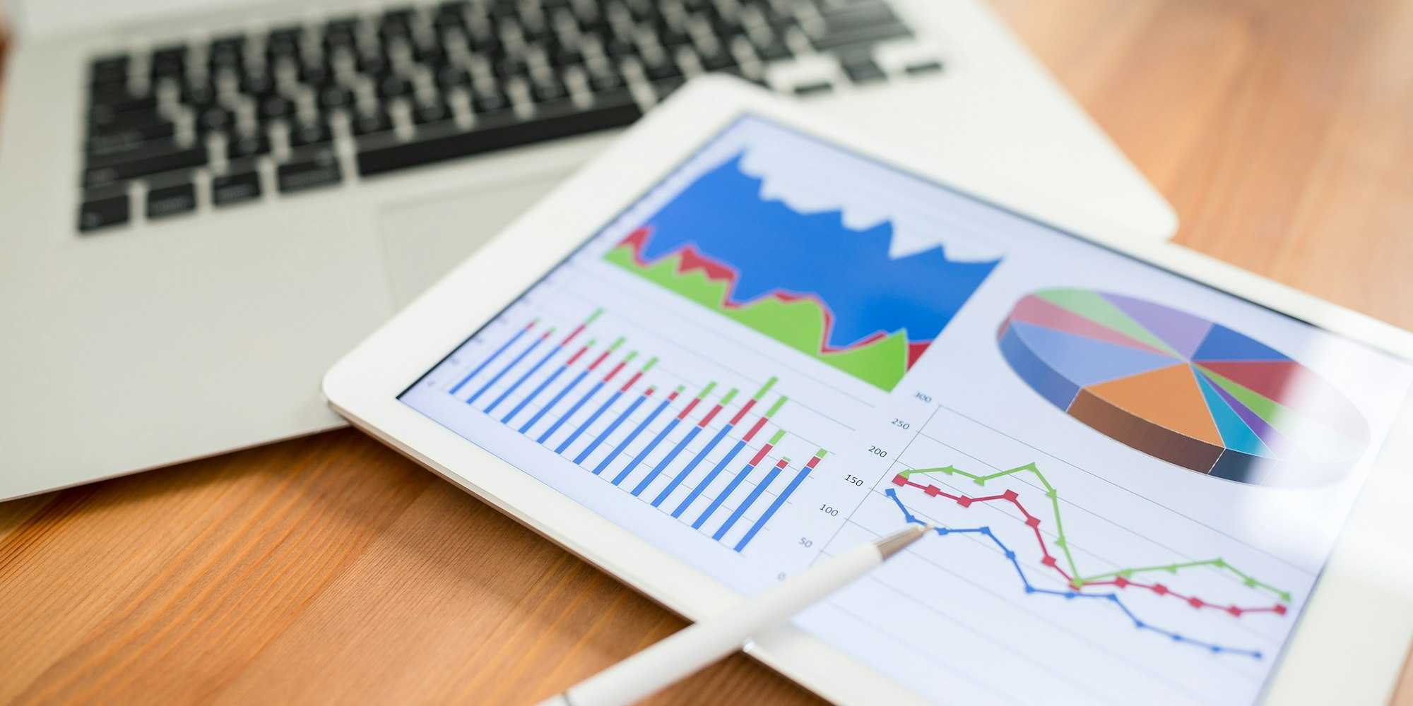 Employee data as graphs on a table near laptop