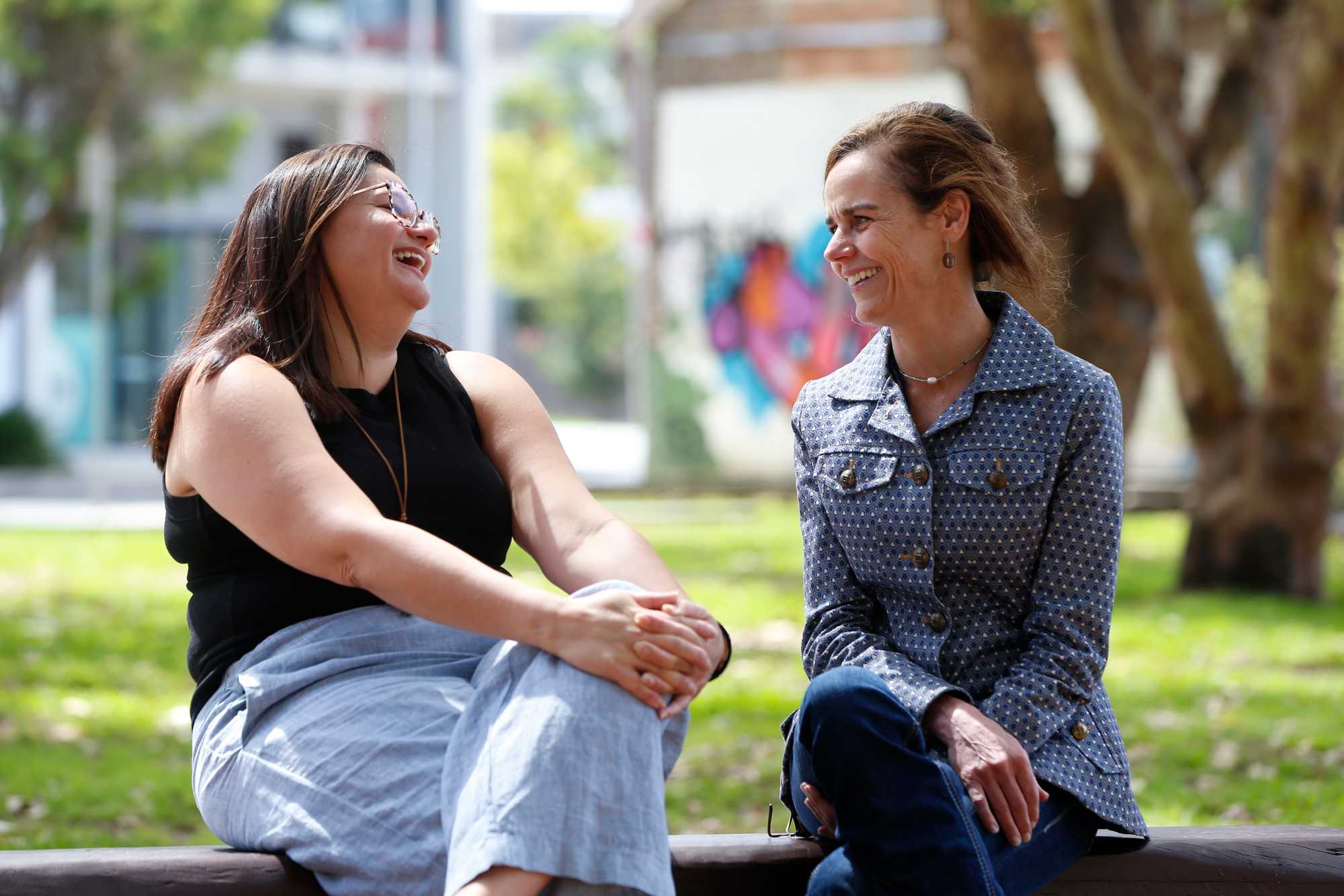 Two woman smiling and connecting in a park