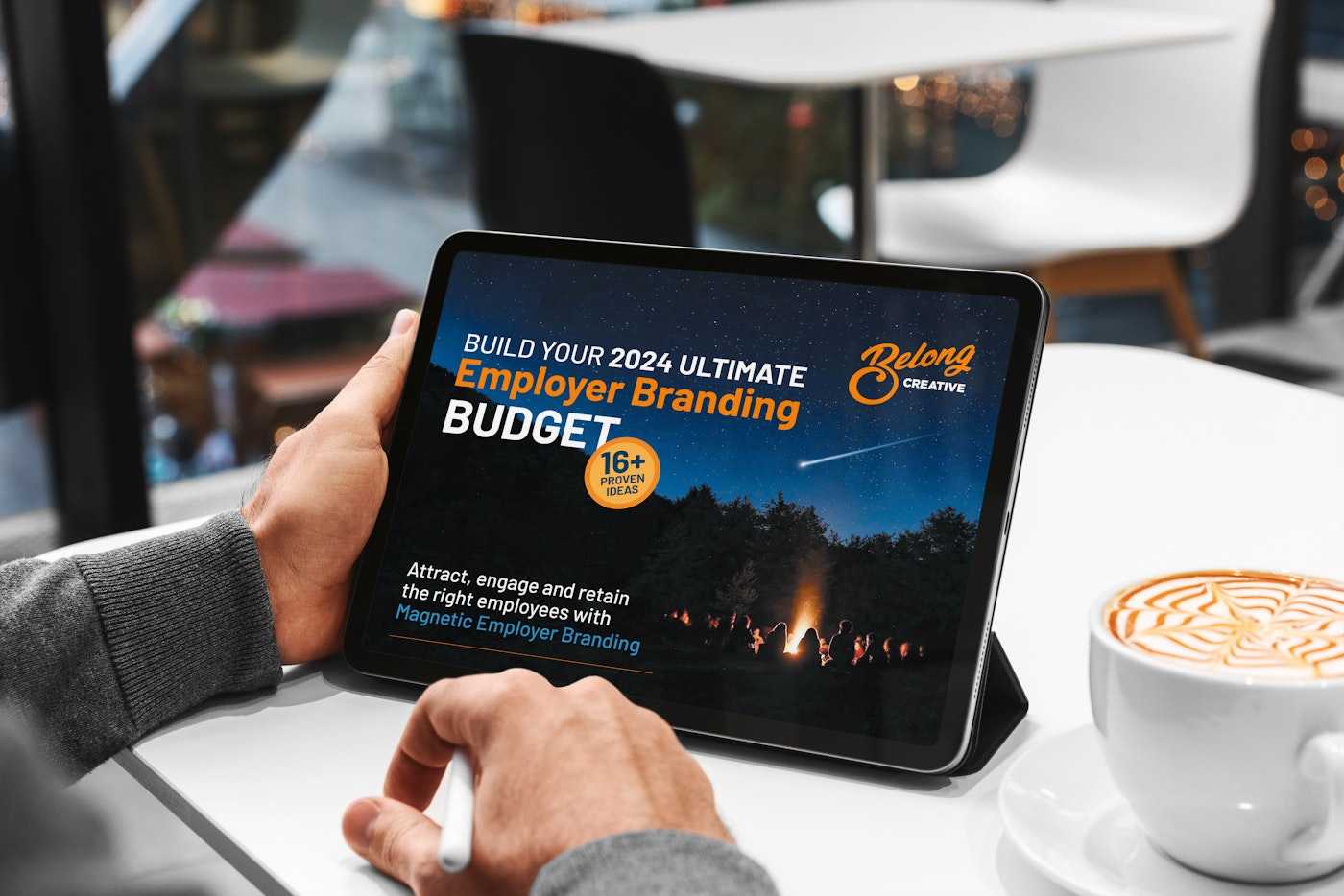 Man at Cafe looking at Employer Brand Budget ebook