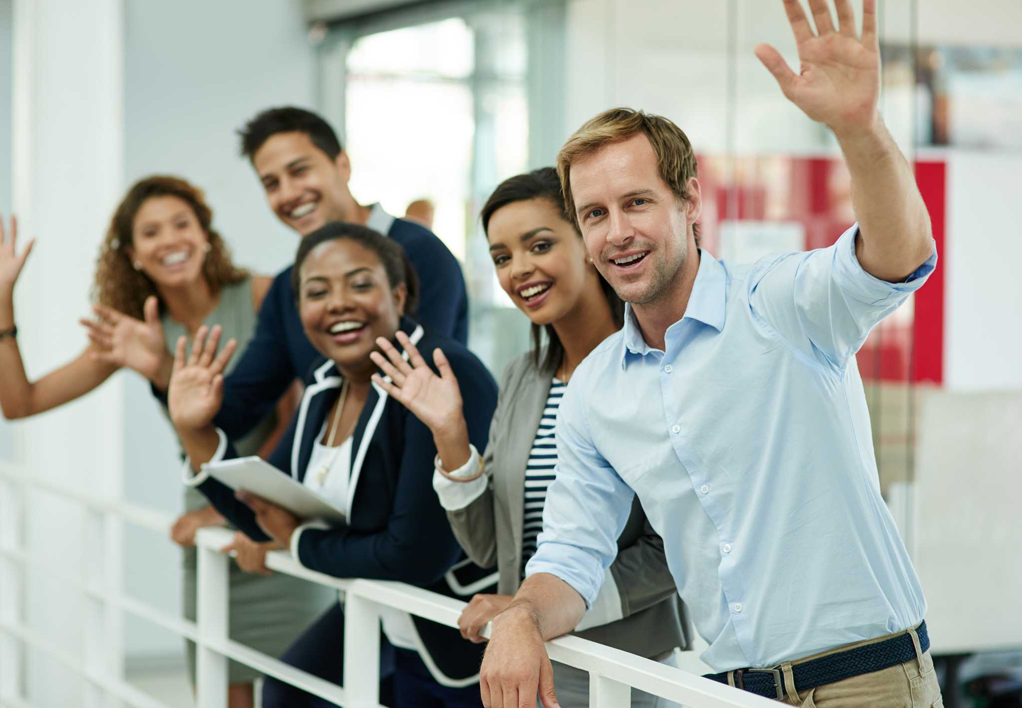 Happy employees waving at camera